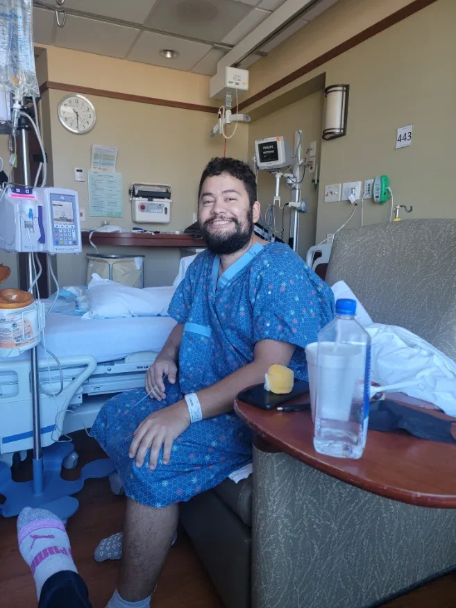 Eduardo Gutierrez smiling in a hospital room during treatment